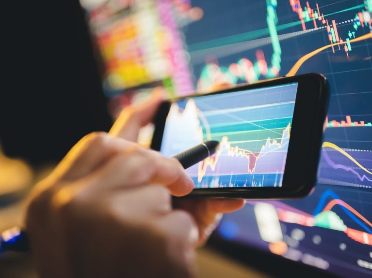 image of data on computer screen and phone